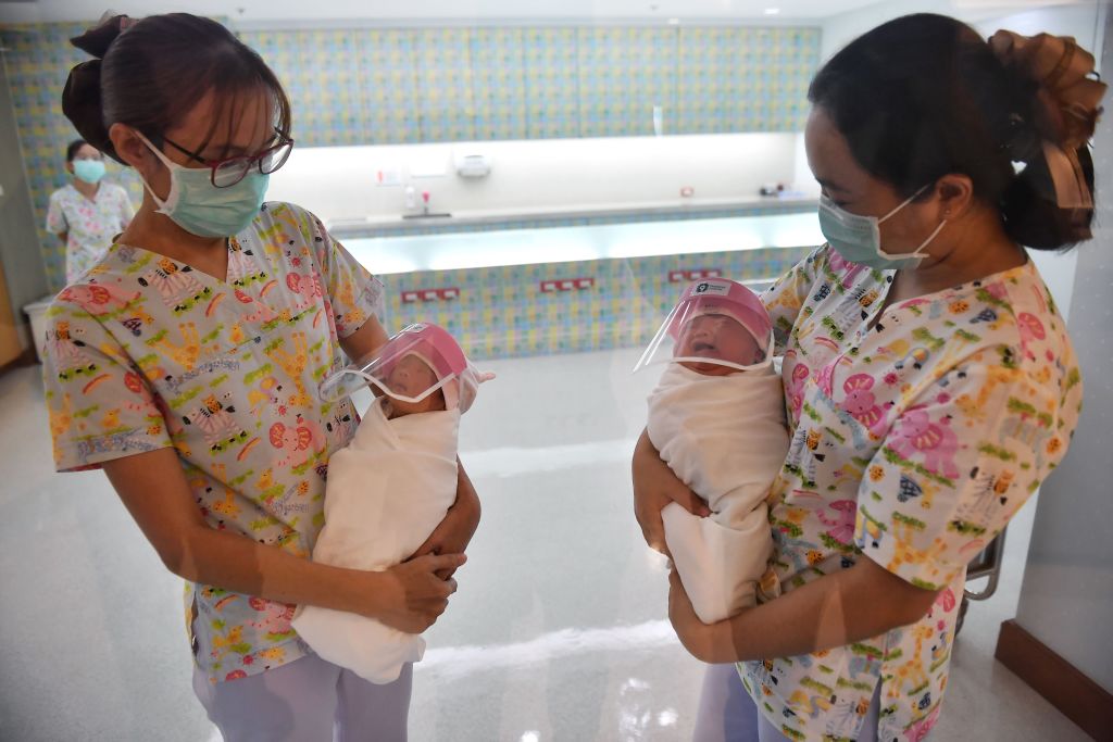 This photo taken through a glass window at a maternity ward shows nurses holding newborn babies wearing face shields, in an effort to halt the spread of the COVID-19 coronavirus, at Praram 9 Hospital in Bangkok on April 9, 2020.