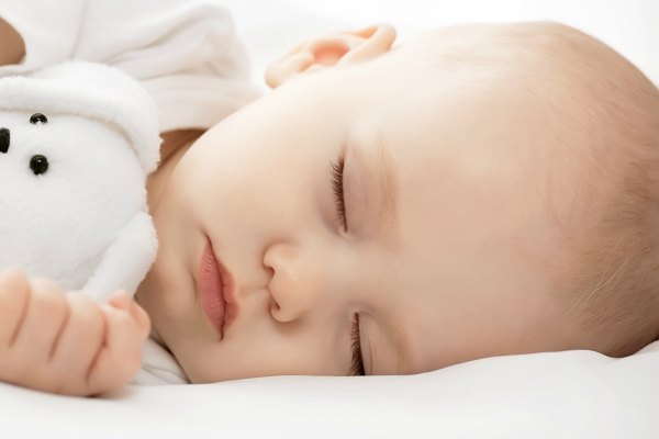 Новорождённый ребёнок спит в обнимку с игрушечным зайчиком