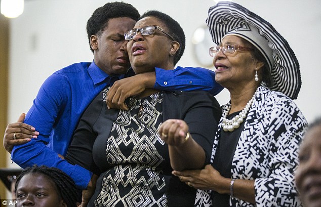 Allison Jean is seen center with her son, Grant, 15 (left) during a prayer service in Dallas on September 9