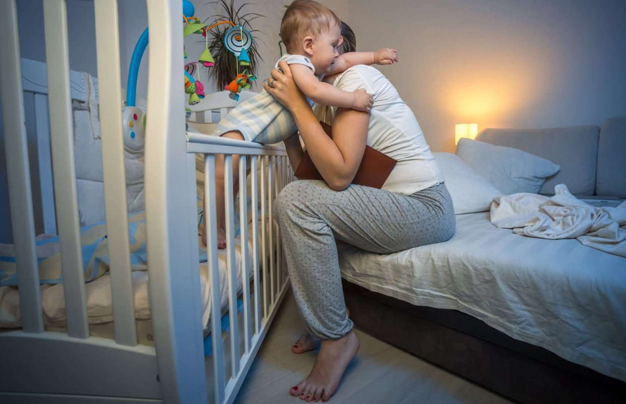 Мама приучает ребенка спать в кроватке