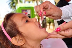 врач капает вакцину в рот ребенку